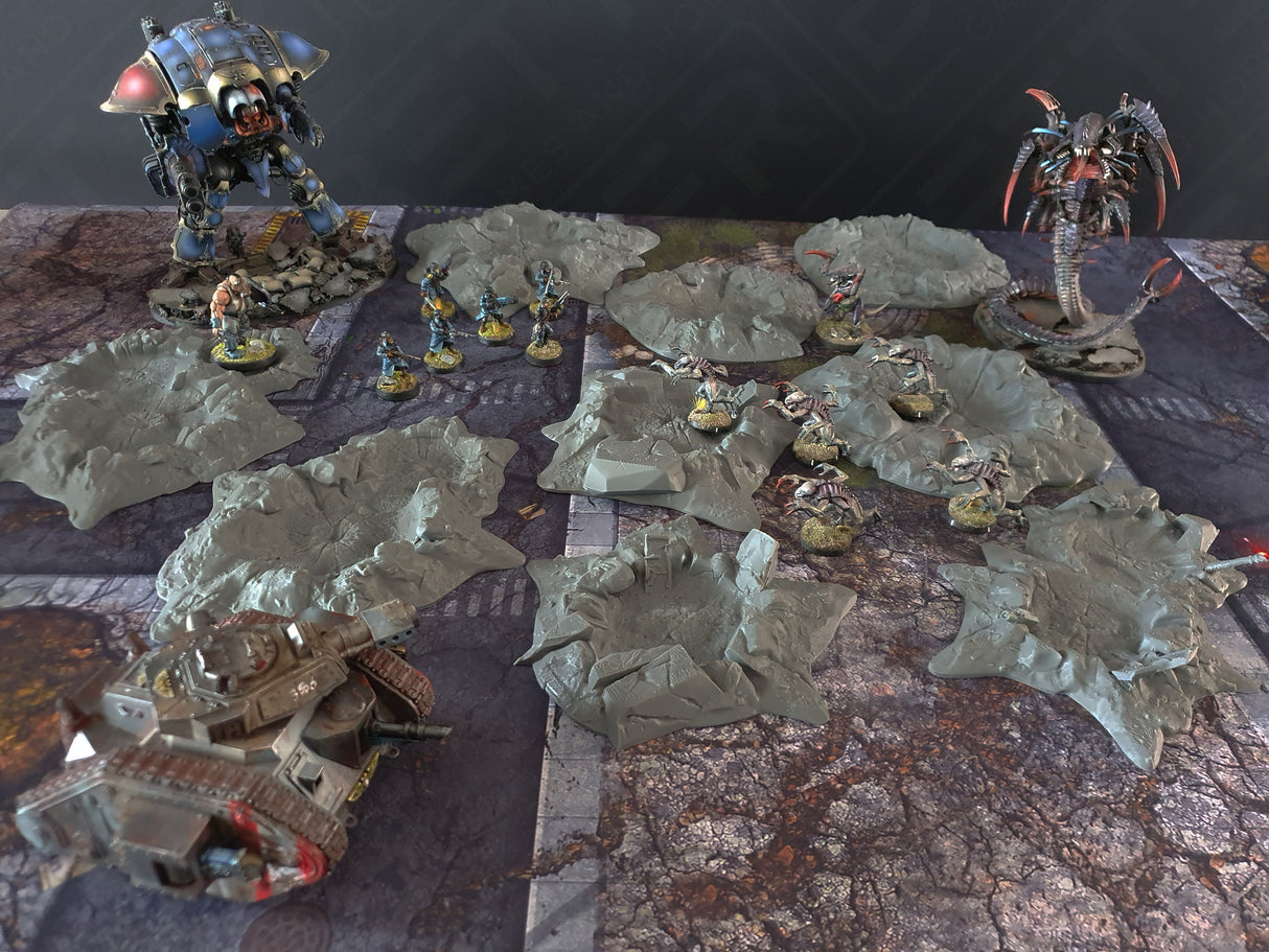 Grey 3D printed wargaming craters scatter terrain set with sci-fi miniatures and tank on battlefield.